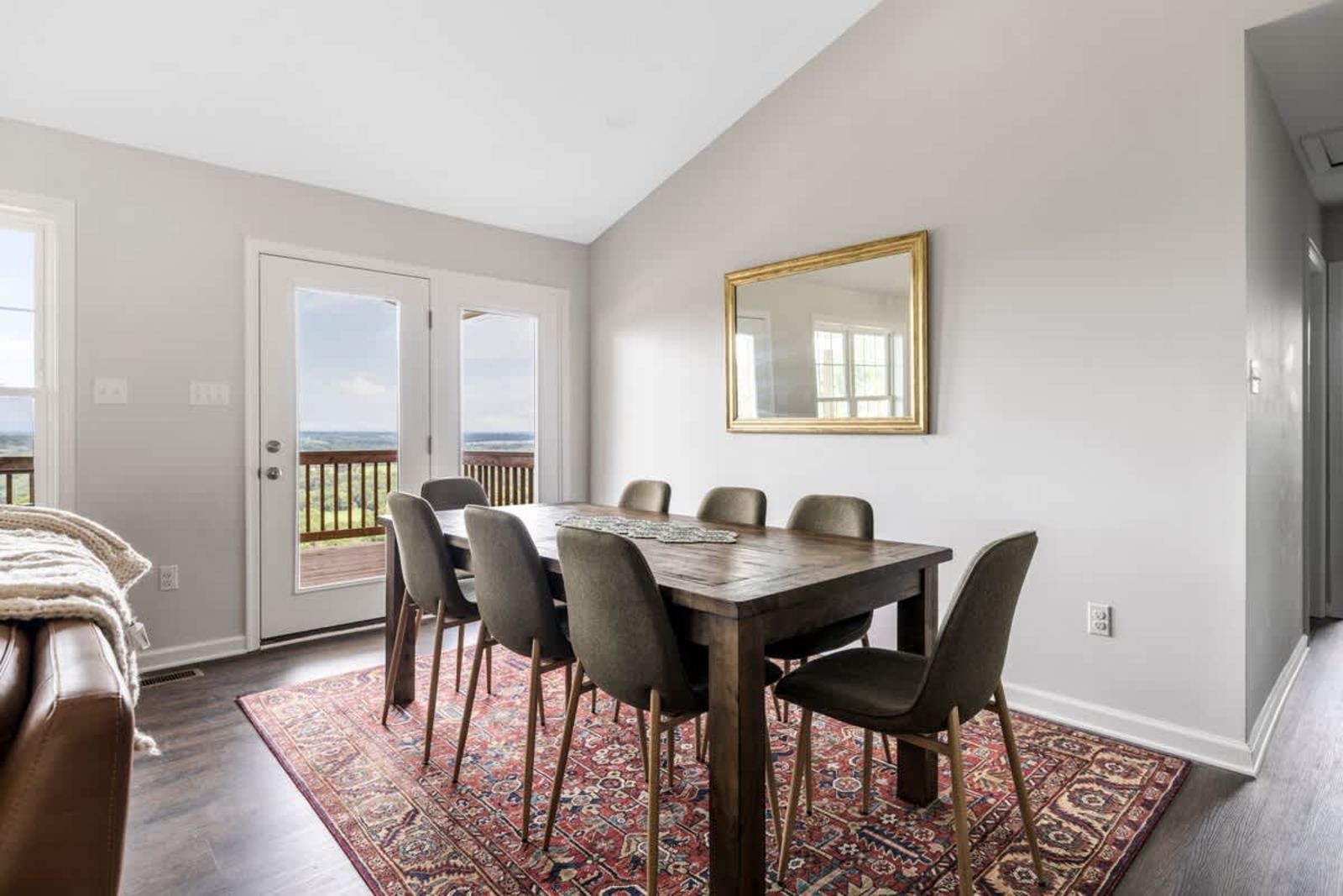 Dining table set for eight beside the deck doors