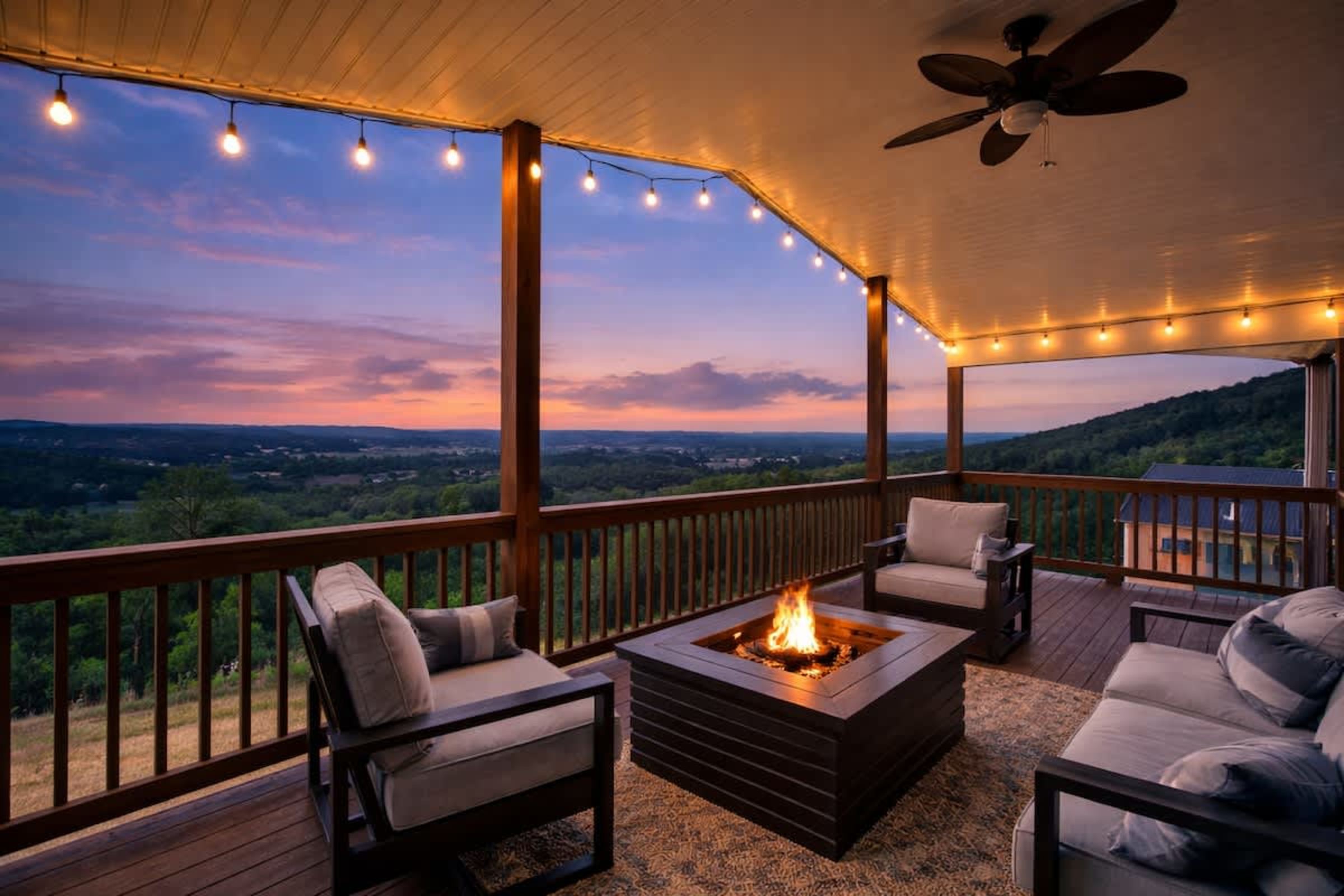 Covered deck at sunset with a fire table, string lights, and the Shenandoah Valley below